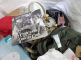 a pile of clothes and a book on a bed