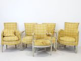 four chairs and a table in a room with a wall in the background