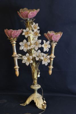 a gold candelab with pink flowers on it