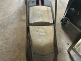 a lawn mower sitting on the floor in a garage