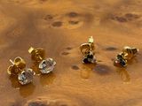 trois paires de boucles d'oreilles en or et diamants posées sur une surface en bois