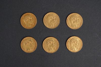 six different types of gold coins are shown on a black surface