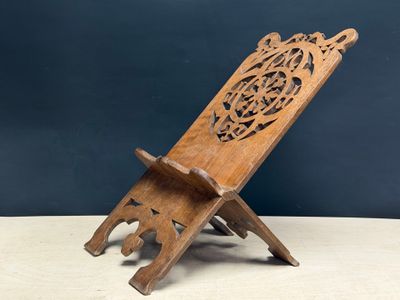 an old wooden stand with a carved design on it