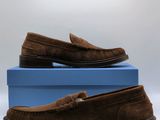 une paire de chaussures en daim marron posée sur une boîte bleue