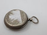 an old silver pocket watch sitting on top of a white table