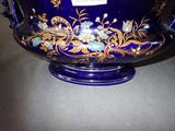 a blue vase with gold and blue flowers on it