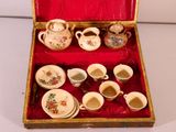 a red box with a set of cups and saucers in it