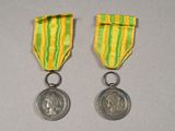 deux médailles avec un ruban et une médaille posée sur une table
