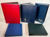Quatre livres de couleurs différentes sont alignés sur une surface blanche.