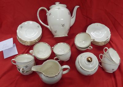 a lot of white and gold china on a red table cloth