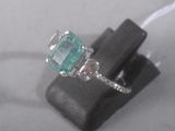 a close up of a ring with a green stone in it