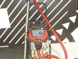 a red and black vacuum and a red hose on the floor