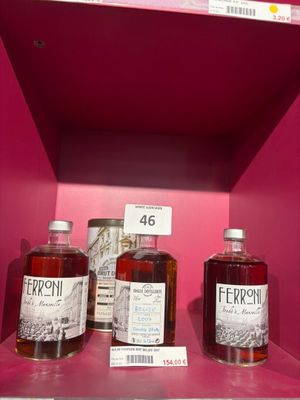 trois bouteilles d'alcool sont posées sur une étagère dans un magasin