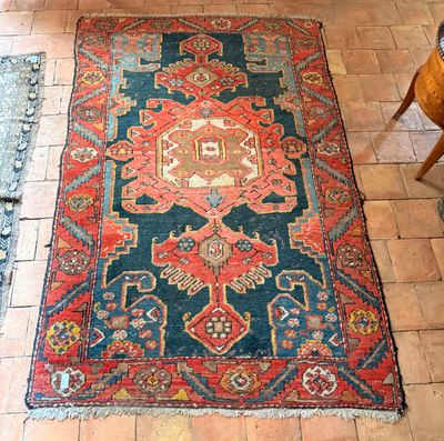un tapis sur le sol avec une chaise en arrière-plan