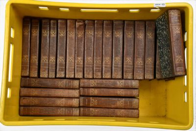 de nombreux livres anciens dans une boîte jaune posée sur la table