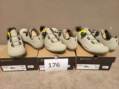 cinq paires de chaussures sont posées sur une boîte sur laquelle est accrochée une étiquette de prix
