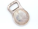 a bottle opener that has a coin in the middle of it