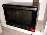 an image of a black oven in the corner of a room