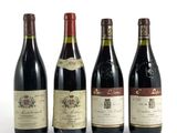 quatre bouteilles de vin sont alignées sur une surface blanche