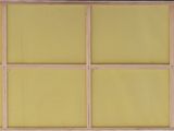 an old window with yellow panels and a wooden frame on the outside