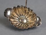 a silver spoon with a flower on it on a table