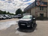 une voiture garée devant un immeuble devant lequel sont garées d'autres voitures