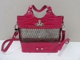 un sac à main rose et argenté posé sur une table blanche, muni d'une bandoulière rose