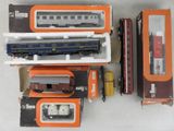 beaucoup de petits trains dans des boîtes, posés sur une table