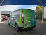 a green van that is parked under a blue tent