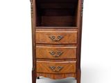 une photo d'une commode en bois comportant trois tiroirs et une étagère