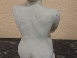 a statue of a woman sitting on a marble table