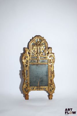 un petit miroir avec un cadre doré posé sur une surface blanche