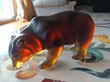 a glass bear that is on a table with a flower pattern