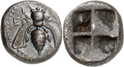 a silver coin with an image of a spider on it