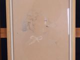 drawing of a woman ' s face in a frame on a shelf