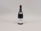 une bouteille de vin rouge posée sur une table blanche