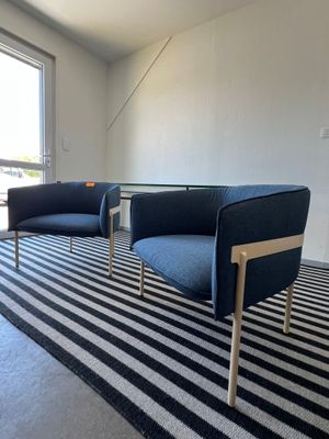 deux chaises et une table dans une pièce où se trouve un tapis rayé