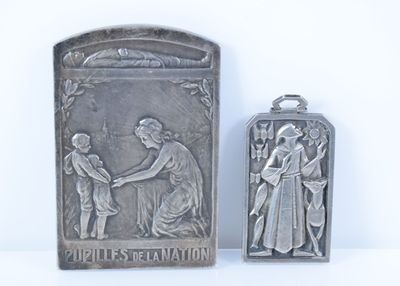 deux plaques métalliques argentées représentant une femme et un homme se serrant la main