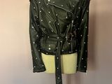 une veste en cuir noir cloutée posée sur un mannequin