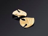 une paire de boucles d'oreilles en or sur une surface noire