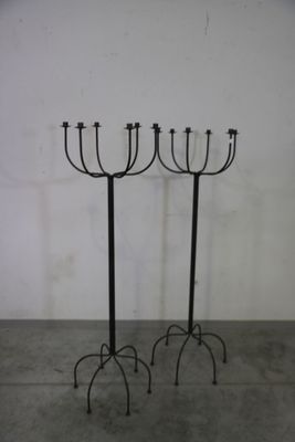 une paire de chandeliers en fer noir surmontés de quatre bougies
