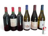 several bottles of wine are lined up on a white surface