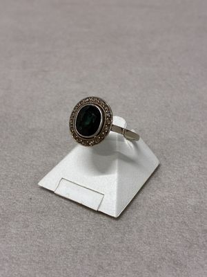 a close up of a silver ring with a green stone on it