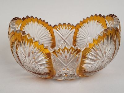 un saladier en verre jaune et blanc posé sur une surface blanche
