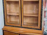 un meuble en bois avec des portes en verre dans une pièce