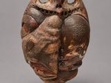 un vase marron orné d'un hibou sur le dessus