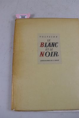 un vieux livre posé sur une table à côté d'une table blanche