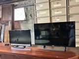 two televisions sitting on top of a wooden table