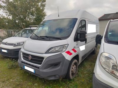 Trois fourgonnettes blanches sont garées les unes à côté des autres sur une pelouse.