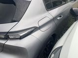 the rear end of a silver car parked next to a white car